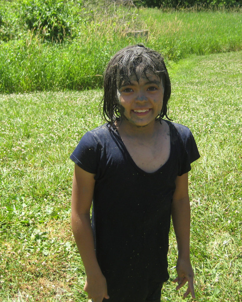 A picture of a young girl who appears to have been playing in the mud