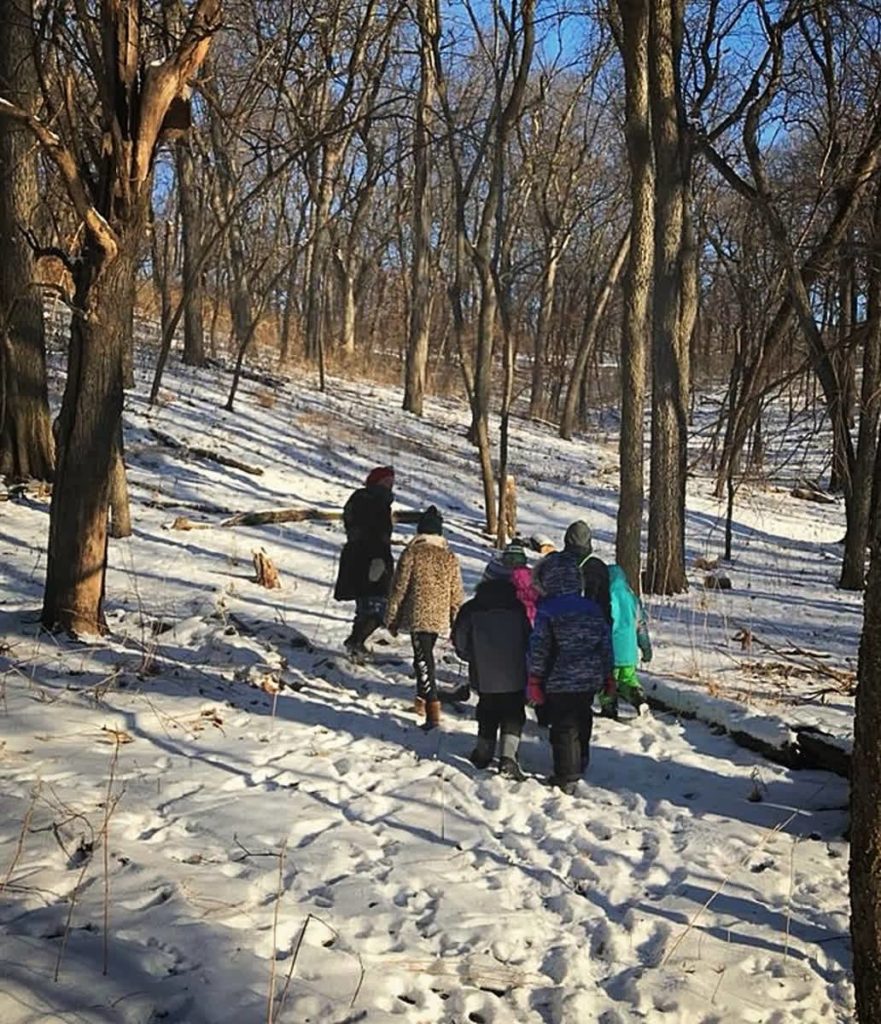 Group of people walking in the snowy trail