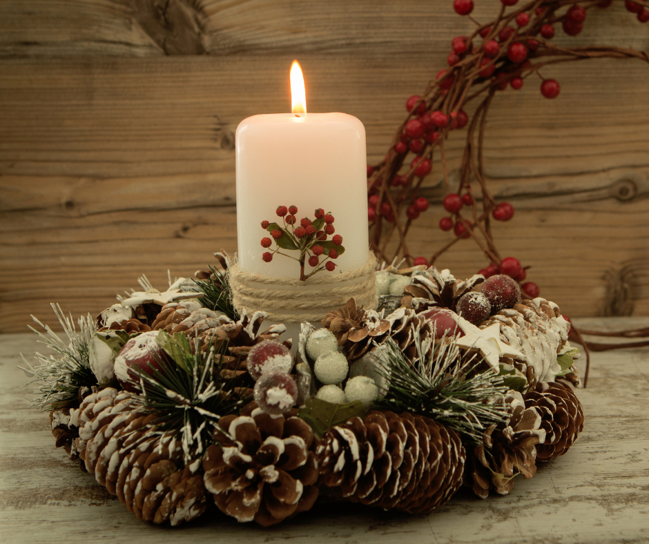 A picture of a rustic holiday centerpiece with a burning candle in the center.