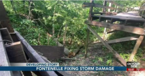 An image of fallen trees damaging the Fontenelle Forest Boardwalk overlayed by a news headline reading "Developing Story: Fontenelle Fixing Storm Damage."