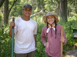An image of two Fontenelle Forest interns smiling while working on the trails.