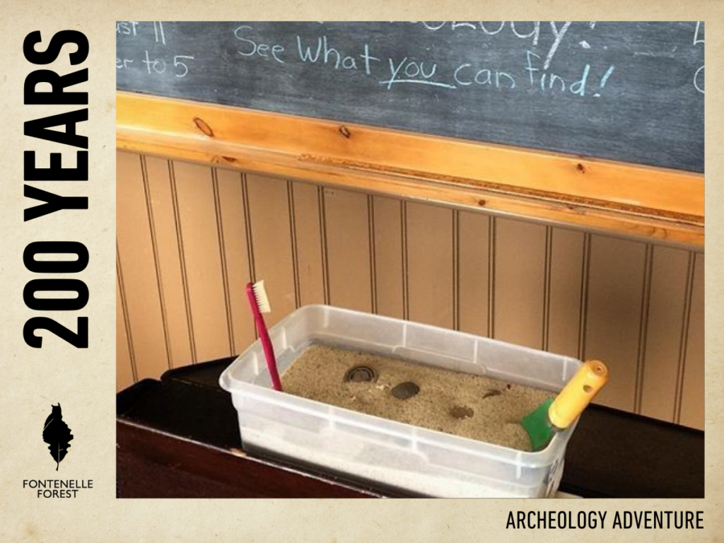 A small rectangular bin with sand inside it for a children's archeology activity