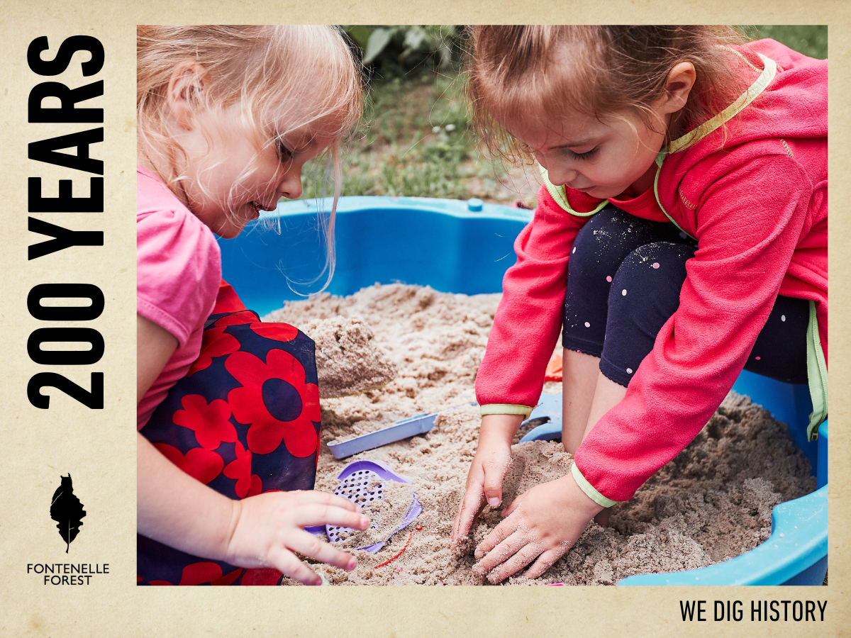 Two children playing in a sand box.
